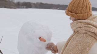 Couple Building Snowman on Winter Day