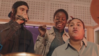 Young multiethnic rap trio rehearsing at music record studio