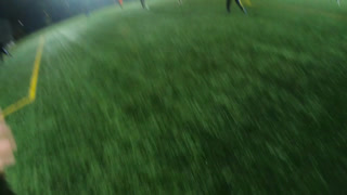 Young soccer player training his skills at football field at evening. Sportsman practicing dribbling ball and kicking it to opponent