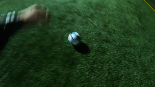 Young soccer player training his skills at football field at evening. Sportsman practicing dribbling ball and kicking it to opponent. Footballer passes the ball to friend. Leisure concept.