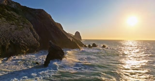 Aerial view of the cliffs of the famous Cabo da Roca are washed by the huge waves of the Atlantic Ocean at sunset