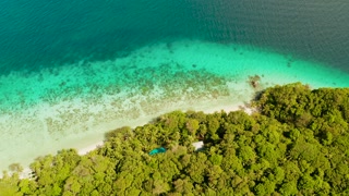 Seascape island coast with forest and palm trees, coral reef with turquoise water, aerial view. Sea water surface in lagoon and coral reef