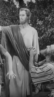 ISRAEL - 1927, in this silent film, Jesus heals a boy who is possessed by the devil. The father hugs his son and kisses Jesus's hand in gratitude. Judas looks on in astonishment.