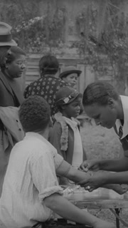 1939 - A black nurse gives a shot to black patients in Georgia.