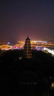 Aerial view of the illuminated Giant Wild Goose Pagoda stands majestically against the cityscape, a beacon of history, Xi'An, Shaanxi, China.