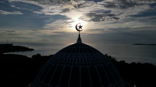 Aerial view of Masjid Raya Nur Ilahi dome at sunset, Indonesia.