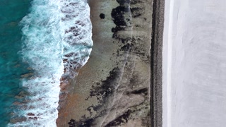 Aerial view of beautiful beach with waves and reef, Maradhoo, Addu Atoll, Maldives.