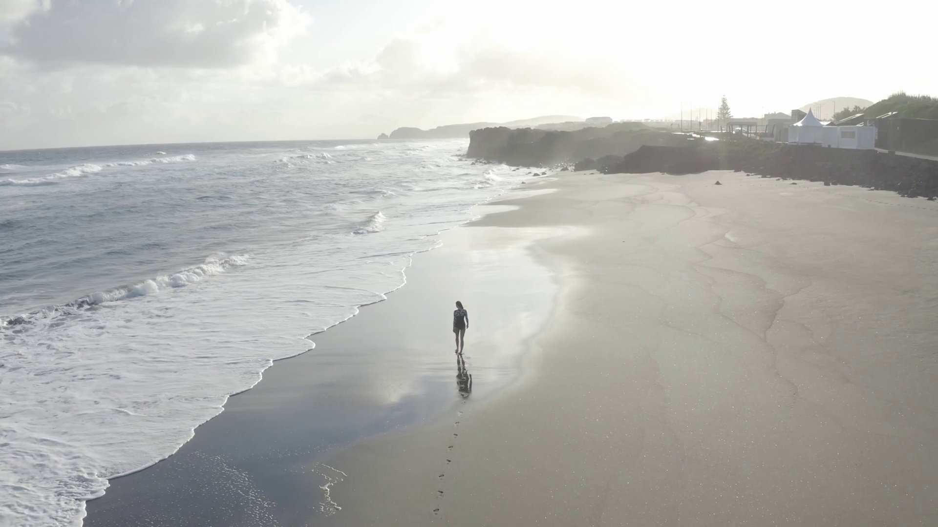 Aerial View of woman walking along the beach, Praia do Areal de Santa Barbara, Ribeira Seca Aerial View of woman walking along the beach, Praia do Areal de Santa Barbara, Ribeira Seca