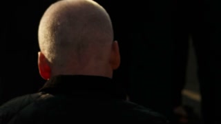 A low key ultra closeup shot of a cross-generation anonymous crowd lit by rim directional sunlight