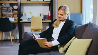 Young woman student or businesswoman reading a book in the library. Students in a good mood studying and reading books in the library.