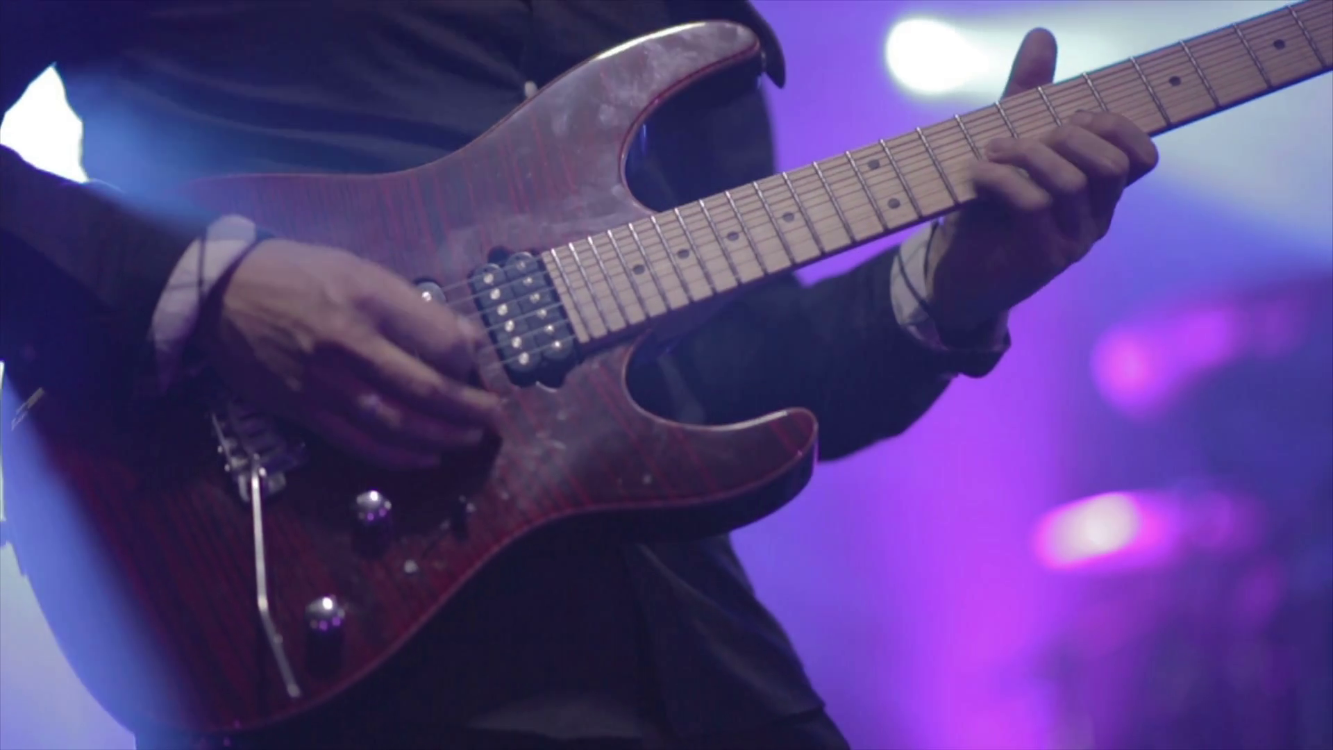 Man lead guitarist playing electrical guitar on concert stage slow