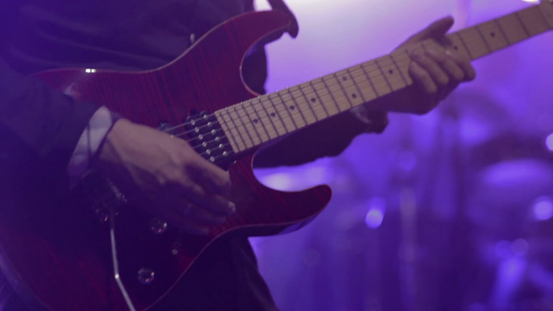 Man lead guitarist playing electrical guitar on concert stage Stock