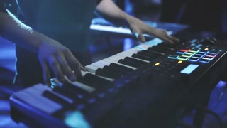 Musician playing on the keyboard synthesizer piano keys. Musician plays a musical instrument on the concert stage