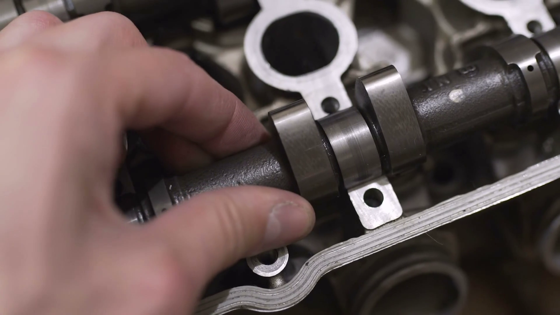 The mechanic man repairs broken engine head, replaces the camshaft ...