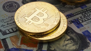 Gold bitcoins and dollars, close-up