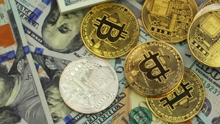 Crypto currency Bitcoin on dollar banknotes background, closeup. Rotate clockwise.