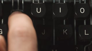 Close up fingers typing on typewriter.