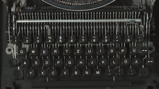 Man's fingers typing on retro typewriter.