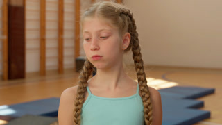 Pensive thinking little girl student education sport class workout training in gym female pupil schoolgirl child kid daughter dancer gymnast