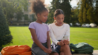 Little kids girls female children friends multiracial ethnic sisters African American Indian schoolgirls pupils elementary students gadget