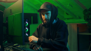 Caucasian man hacker computer looking at camera programming pc scam networking male guy spying thief virtual dangerous criminal coding web