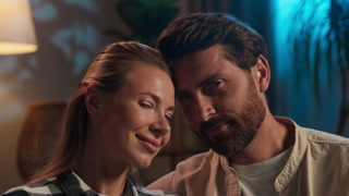 Caucasian married happy touching foreheads cuddling looking at camera smiling valentines day anniversary at evening home wife cuddle with