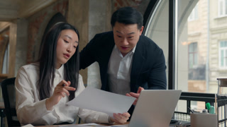 Two Asian business workers in office happy result data handshaking boss support intern woman Korean businesswoman with paperwork stats