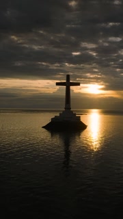 A large cross in the sea with sunset background. Panorama view of Sunken Cemetery in Camiguin Island. Philippines. Vertical video.