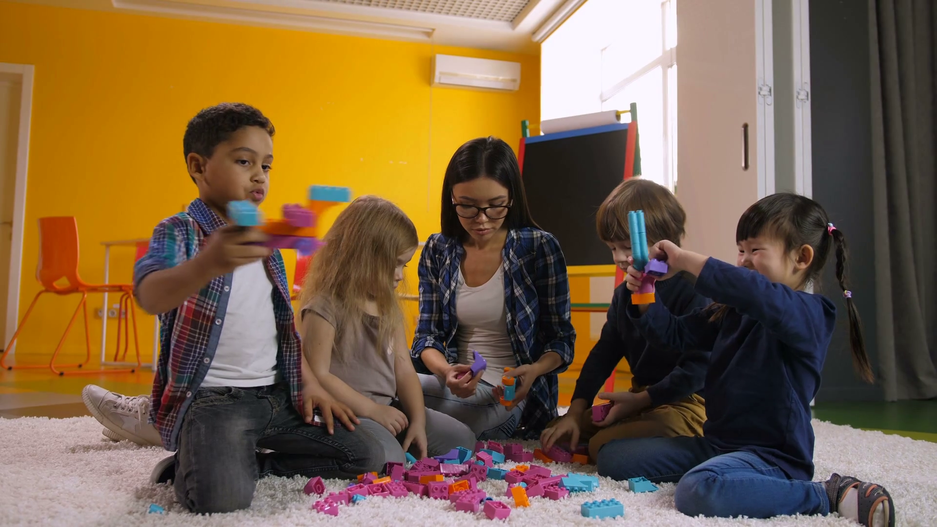 Carefree multicultural diverse children and teacher having fun with