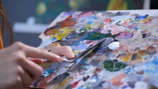 Close Up Of Female Painter Hands With Palette Knife Mixing Colorful Acrylic Paints On Canvas Panel Before Creating A Painting In Own Workshop Artist Hand Holding Colored Palette Preparing For Drawing Stock Video