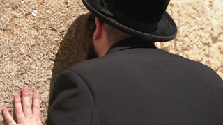 Jewish man praying and crying at the Wailing Wall