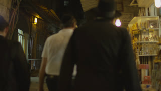 Men walking by the stores at night
