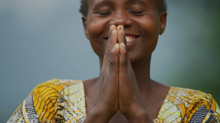 African woman praying and smiling