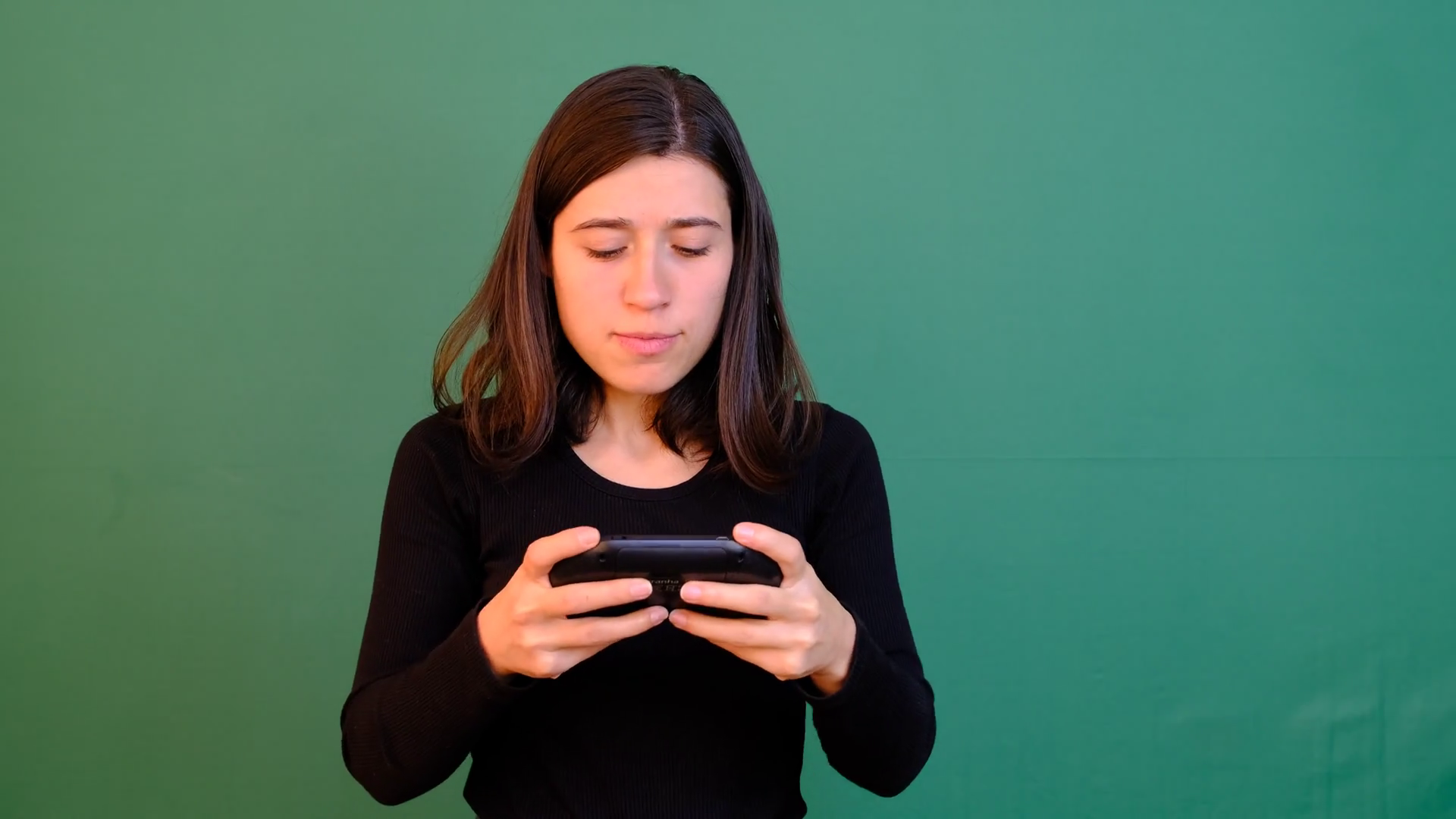 Girl Playing Game With Phone On Green Screen Stock Footage SBV