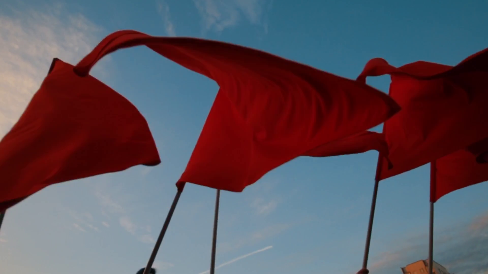 Crowd Waving Red Flags Against Blue Sky Stock Footage SBV332360444