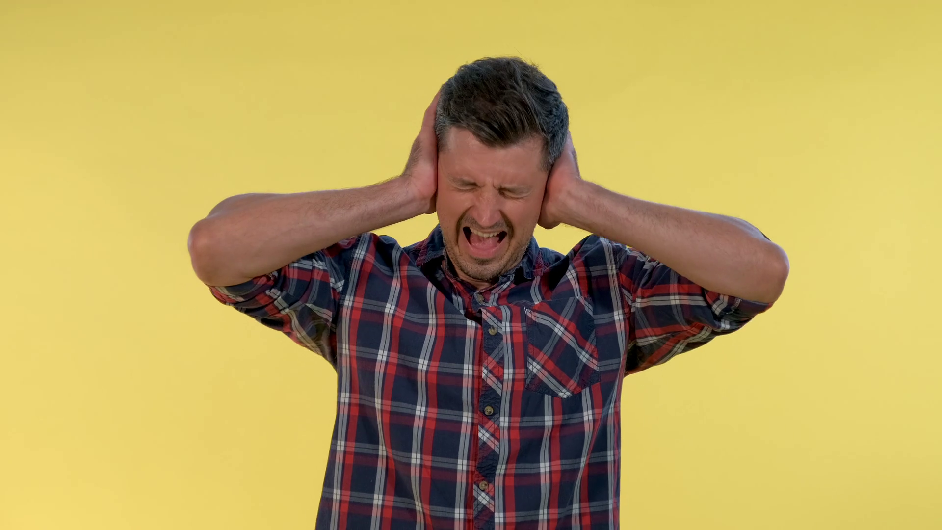 Scared Desperate Man Screaming And Covering Ears On Yellow Background He Is Annoyed With Loud 