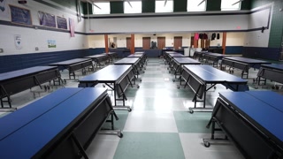 Lunch Setup in Junior High Cafeteria With Tables Arranged for Midday Meal