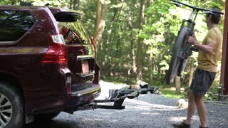 Mounting a Bike Onto a Car Rack With a Trailer Hitch in a Wooded Area
