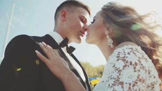 Bride and groom kissing in sunshine close up