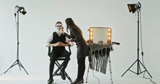 The backstage process of a guy's makeup creating the image of a dead groom on Halloween in the studio
