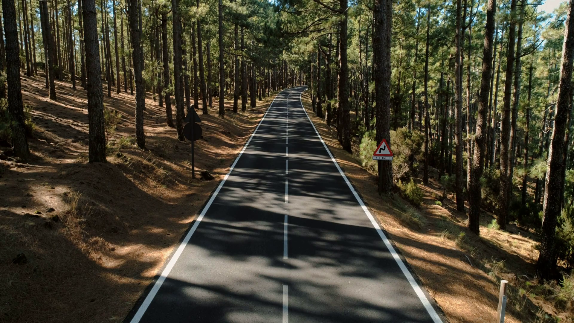 Aerial drone footage of empty mountain forest road on ...