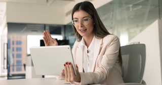 Happy Latin businesswoman in glasses talking on video conference chat
