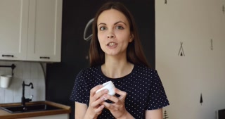 Young beauty blogger promoting facial cream.