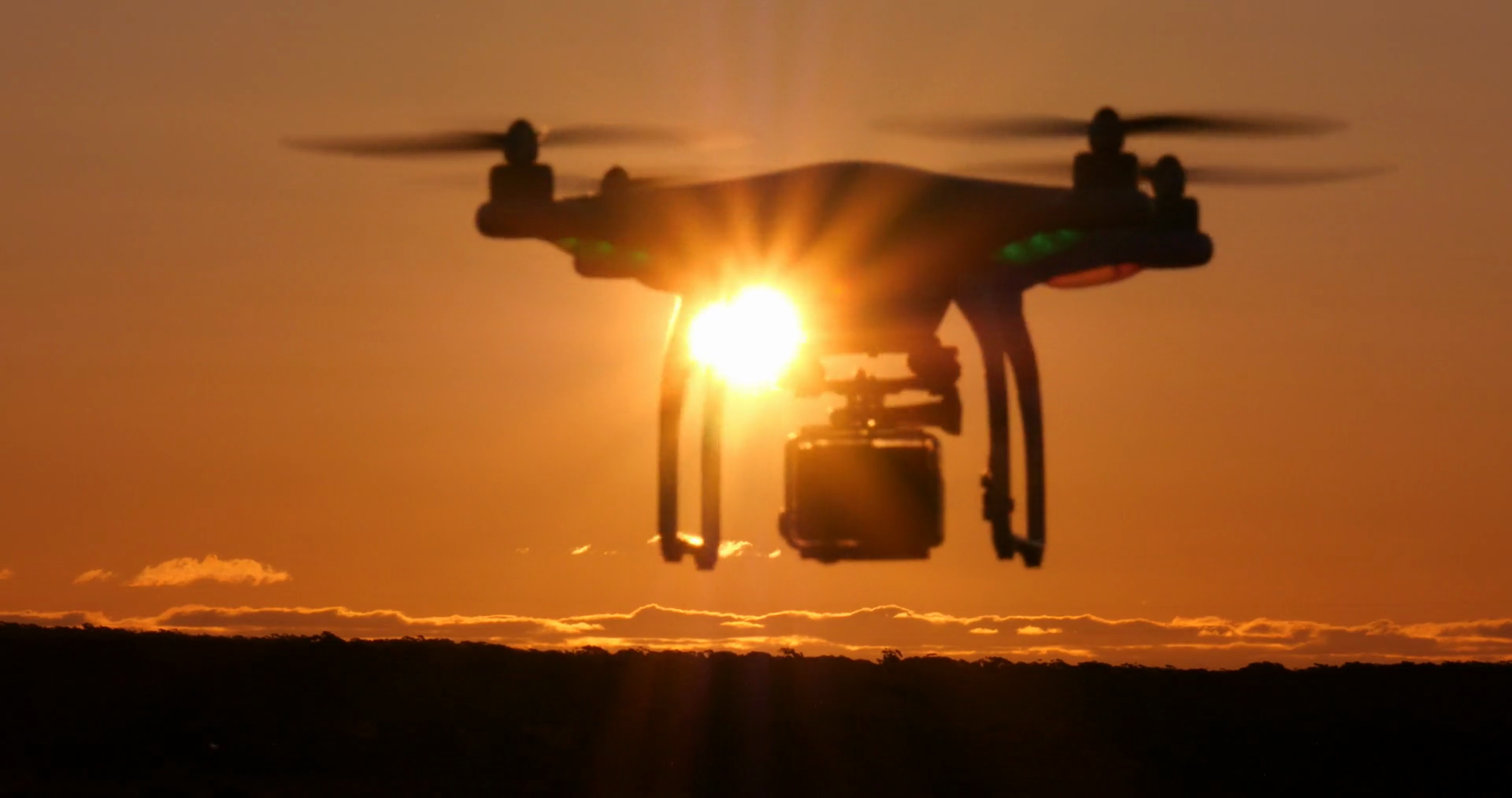 Drone quadcopter multirotor flying with camera during sunset Stock