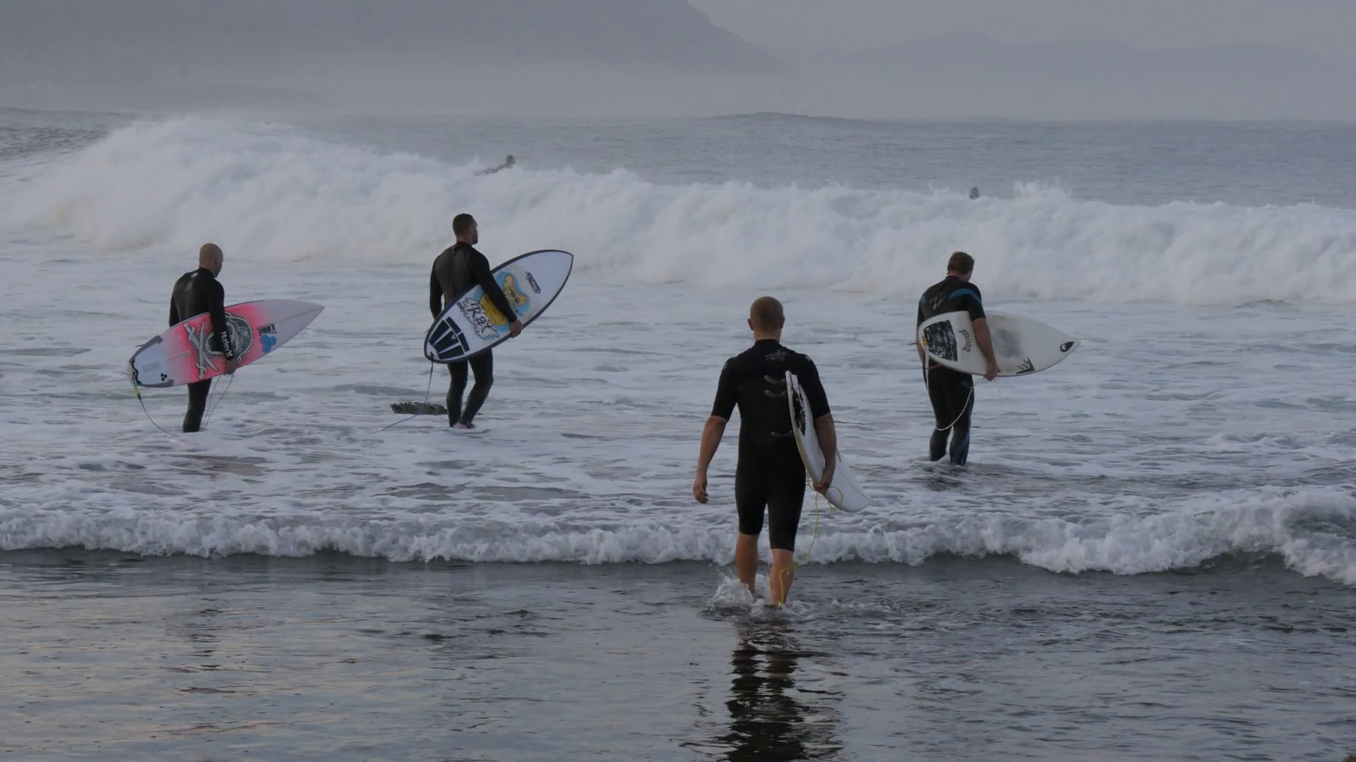 WOLLONGONG, AUSTRALIA Surfers with surfboards walking into surf Stock