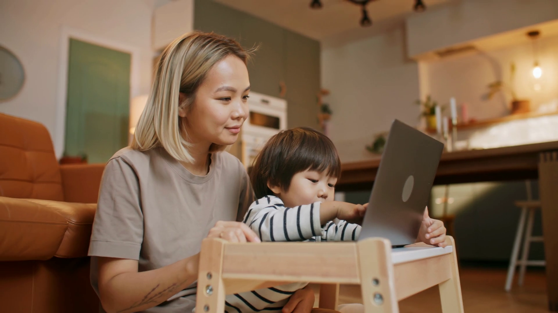 Happy smiling asian mother teach little child boy watch internet videos ...