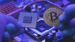 Closeup of man hands in gloves hold gold Bitcoin and cpu on motherboard background. Person shows future currency. Mining, trading. Cryptocurrency in the fingers