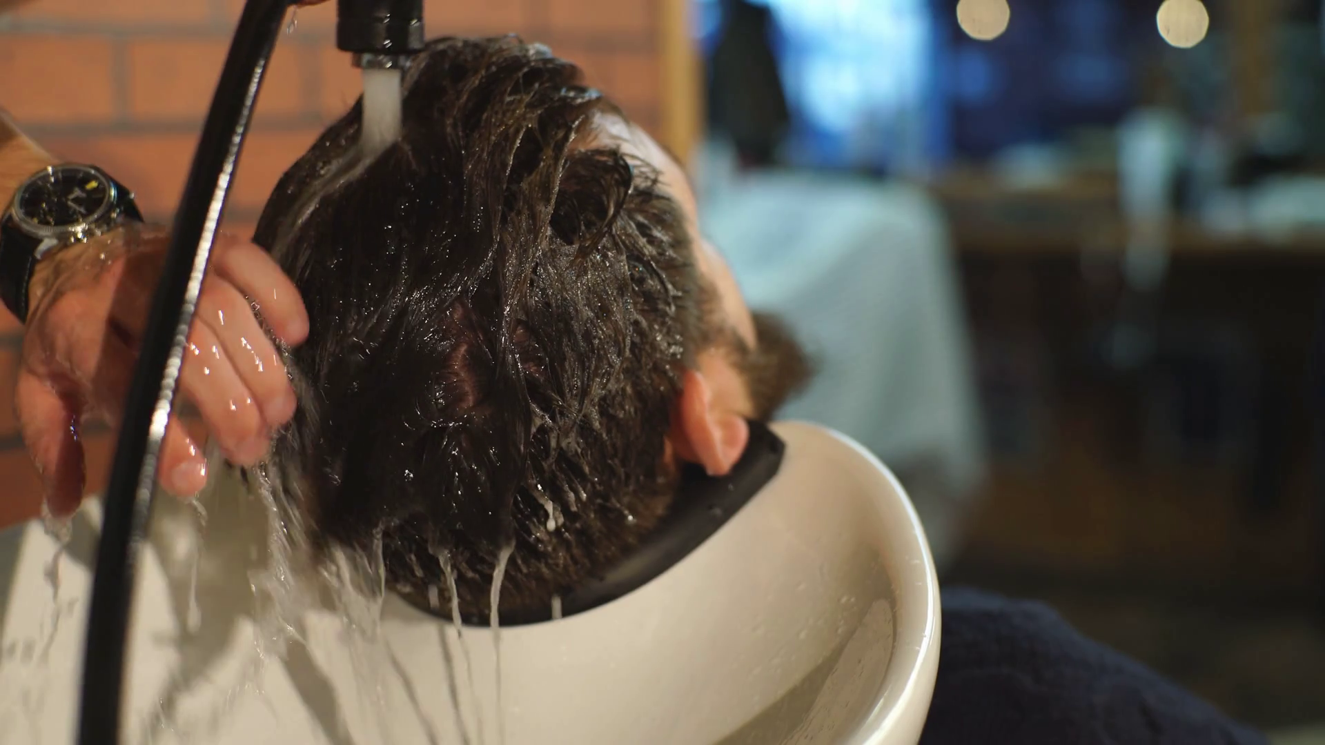 Hairstylist washing client's hair in barber shop Stock Video Footage