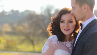 Beautiful young bride and groom posing at sunset in slow motion - close up