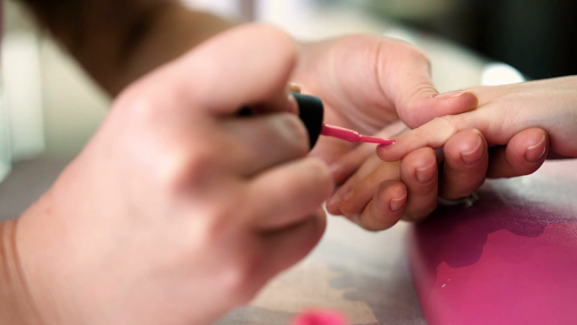 Nail artist doing manicure for little girl in professional salon. Close